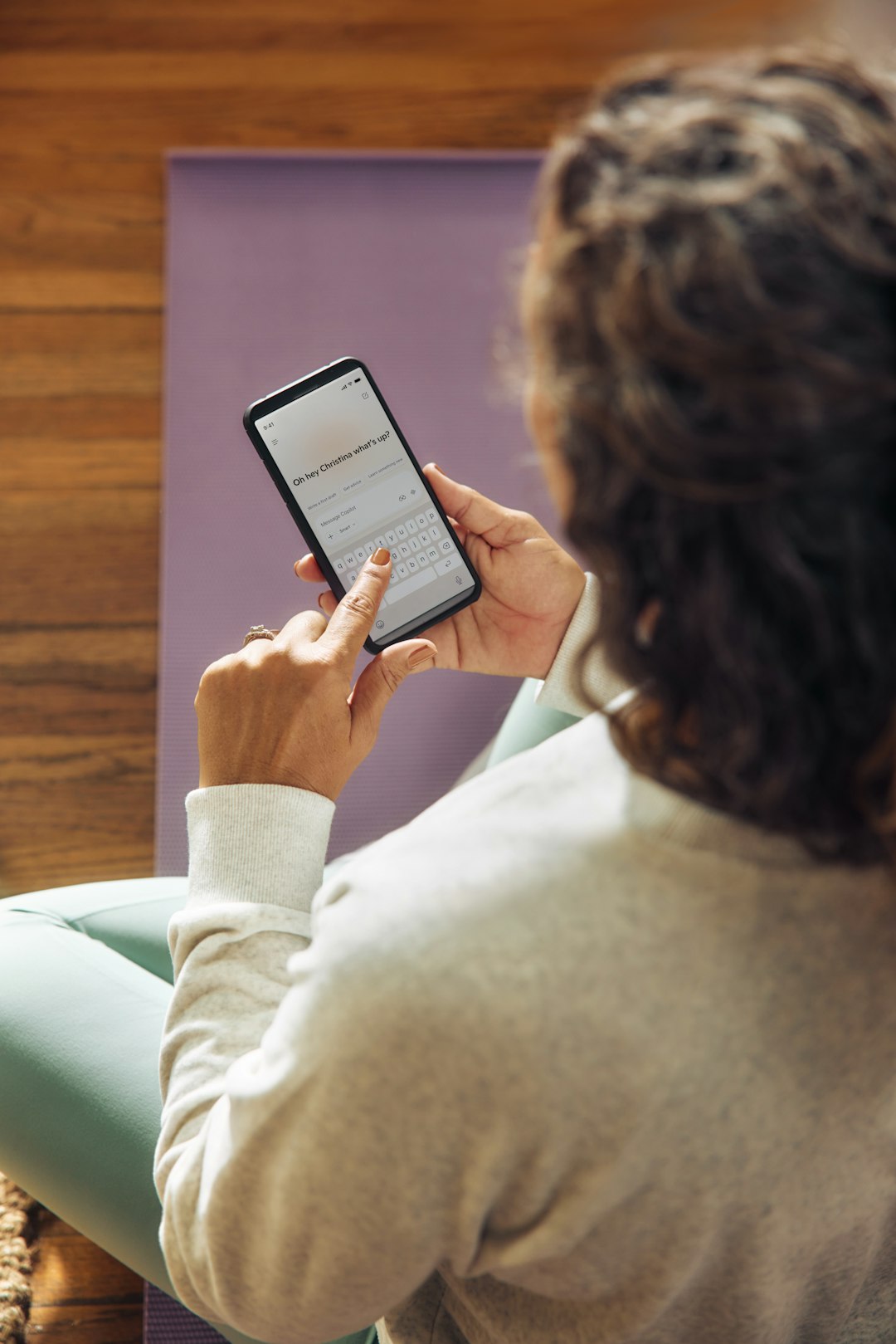 woman-using-a-smartphone-on-a-yoga-mat-qvvi6vaqtg8